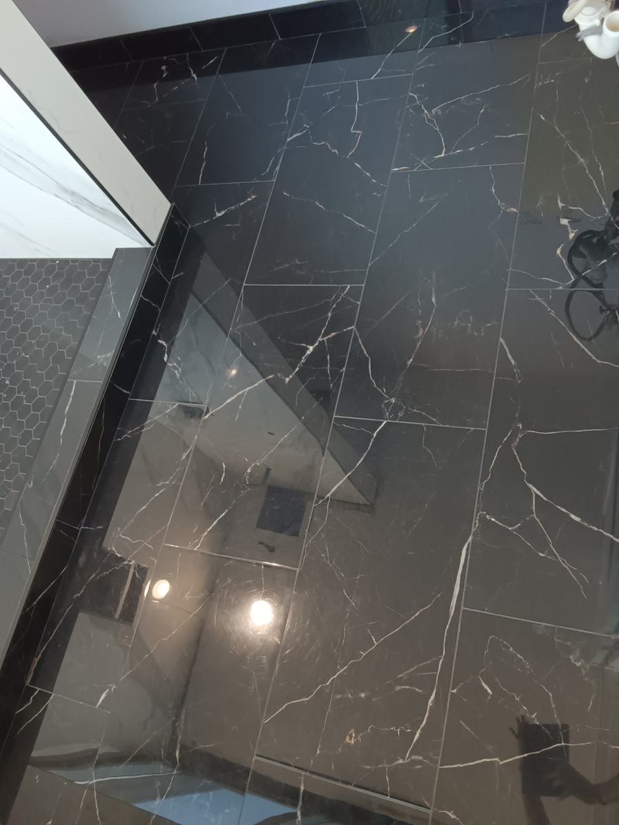 Black marble-look shower with frameless glass