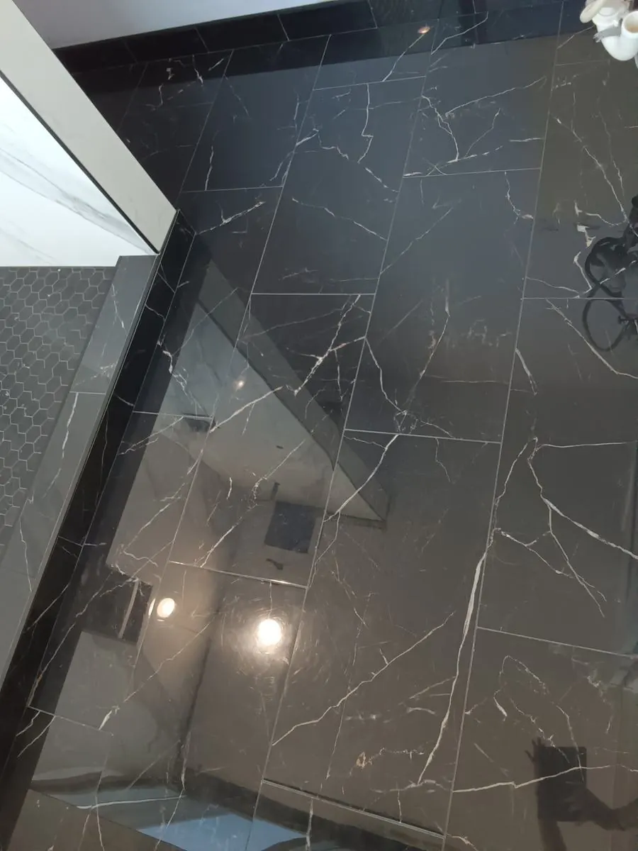 Black marble-look shower with frameless glass