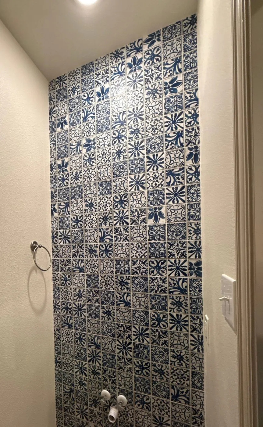 Blue-and-white patterned tile feature wall in a half bath