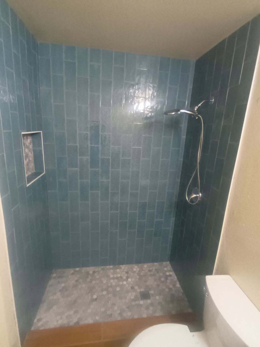 Shower in blue glazed tile with a recessed niche