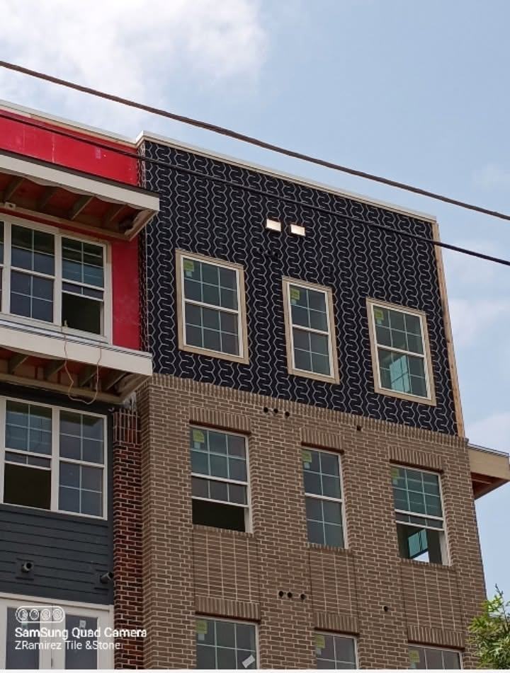 Geometric navy tile cladding on the upper floors of an apartment building