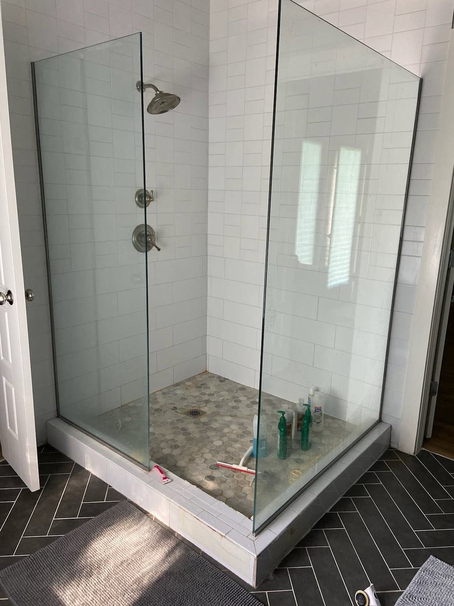 Subway tile shower with hex floor and glass door