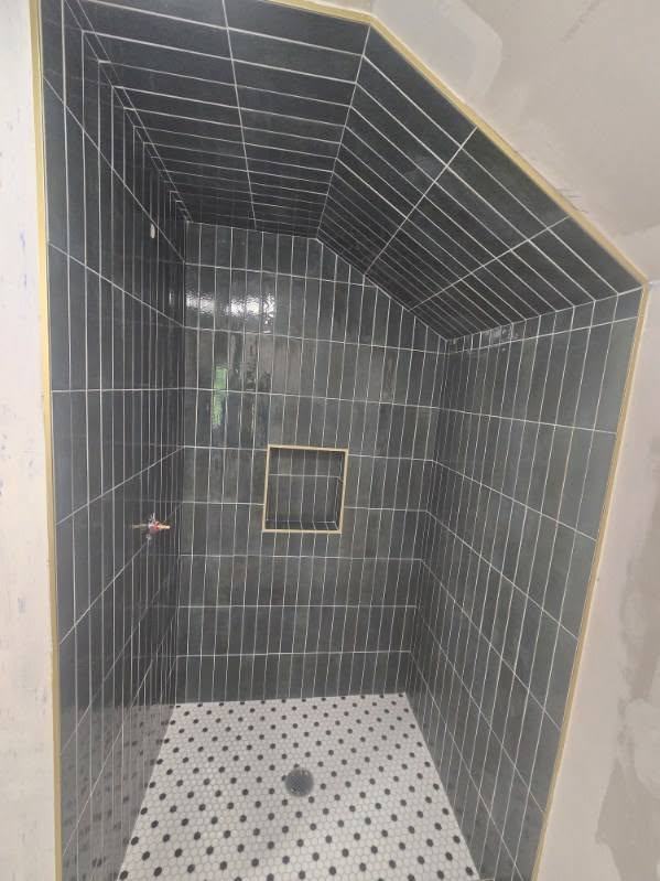 Gray subway tile shower with penny tile floor