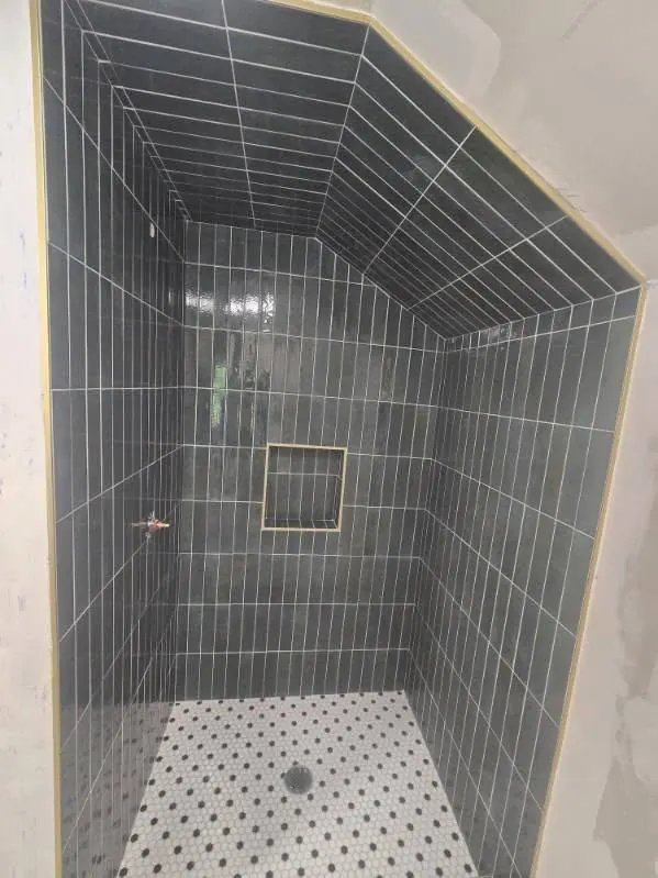 Gray subway tile shower with penny tile floor