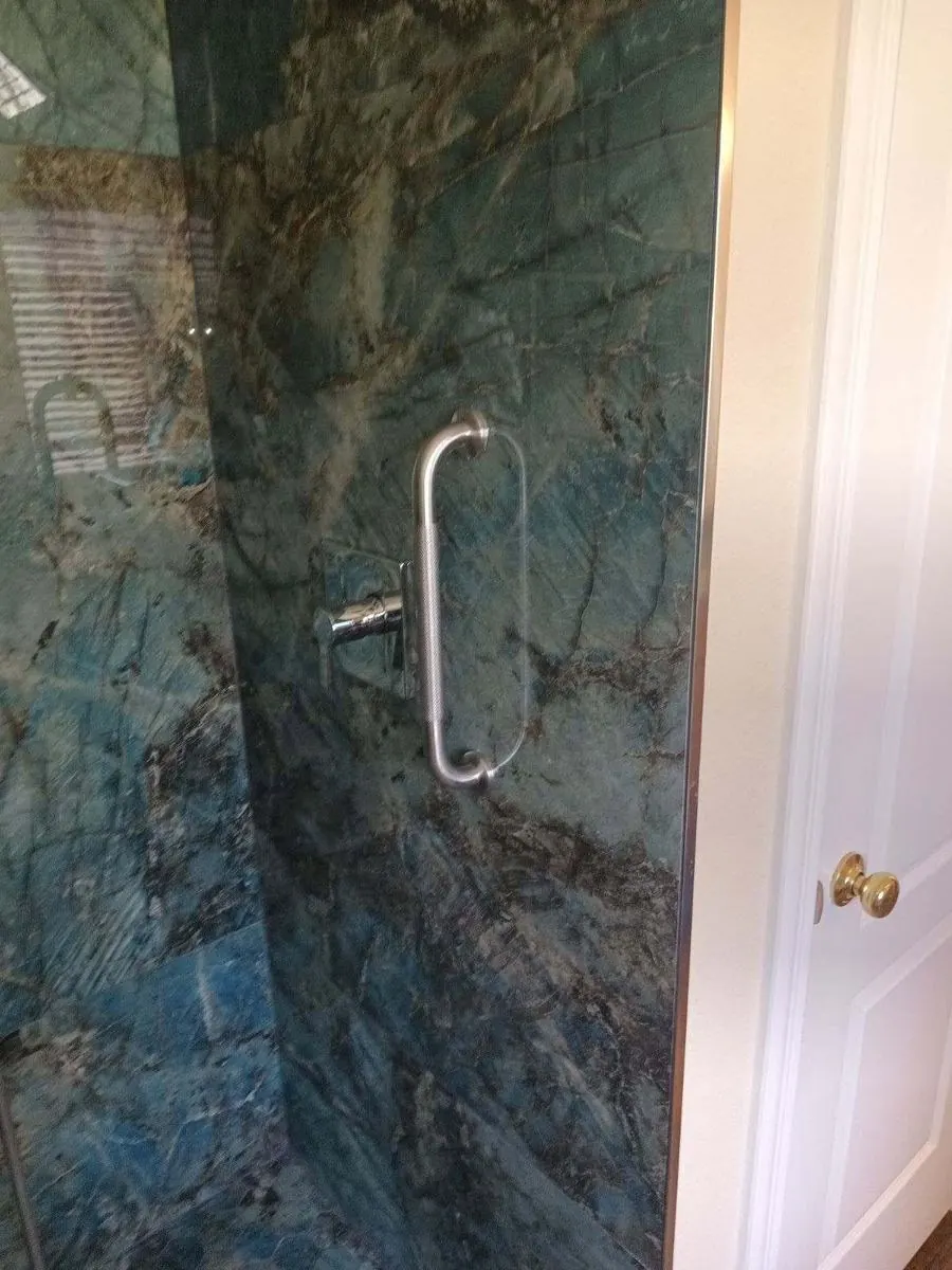 Green marble-look shower behind frameless glass