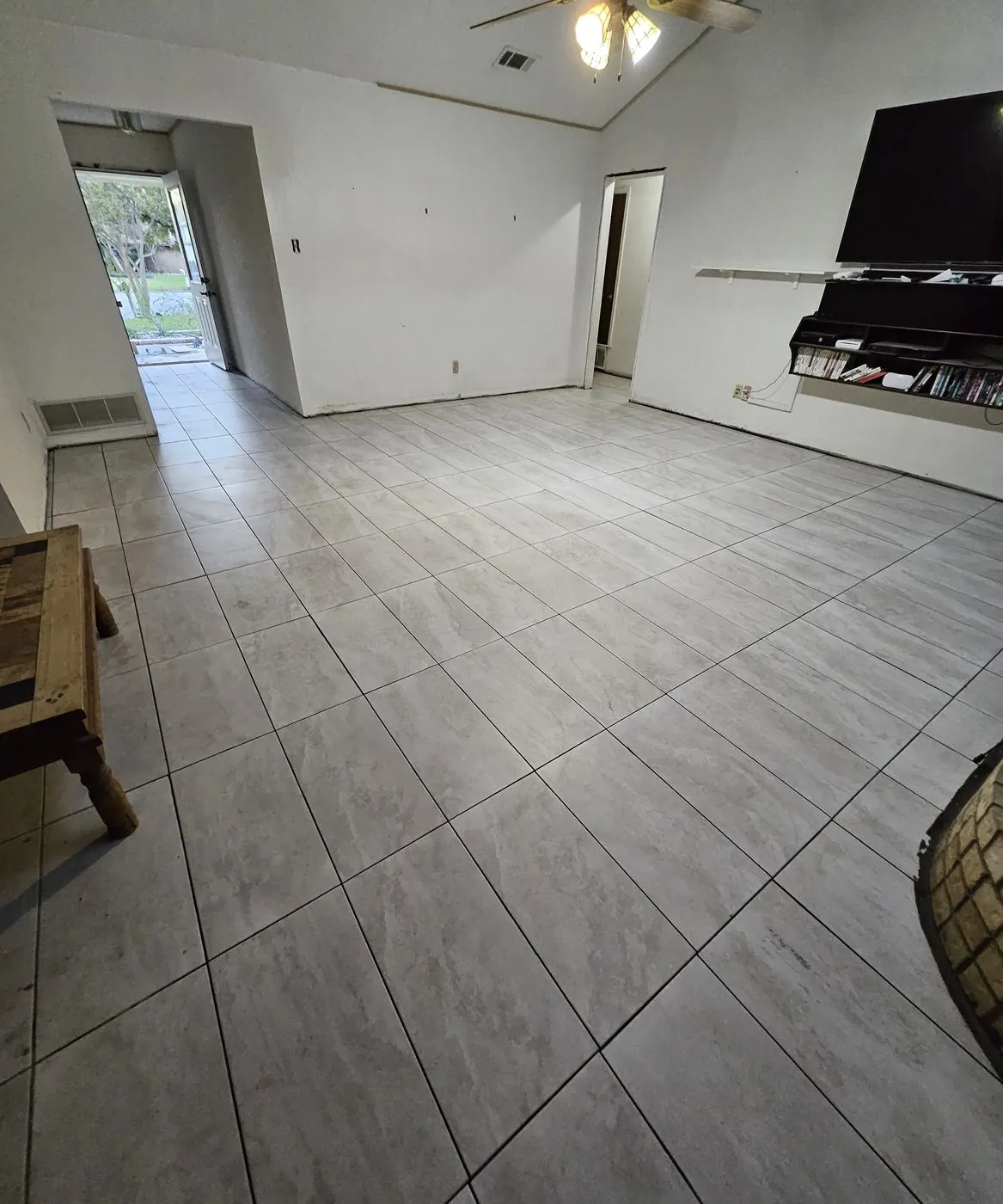 After: Living-room tile floor with stained grout lines, finished