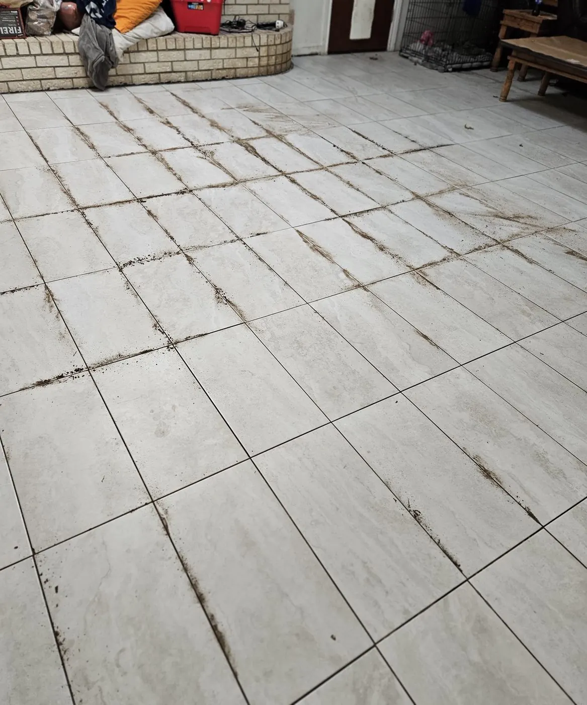 Before: Living-room tile floor with stained grout lines, finished