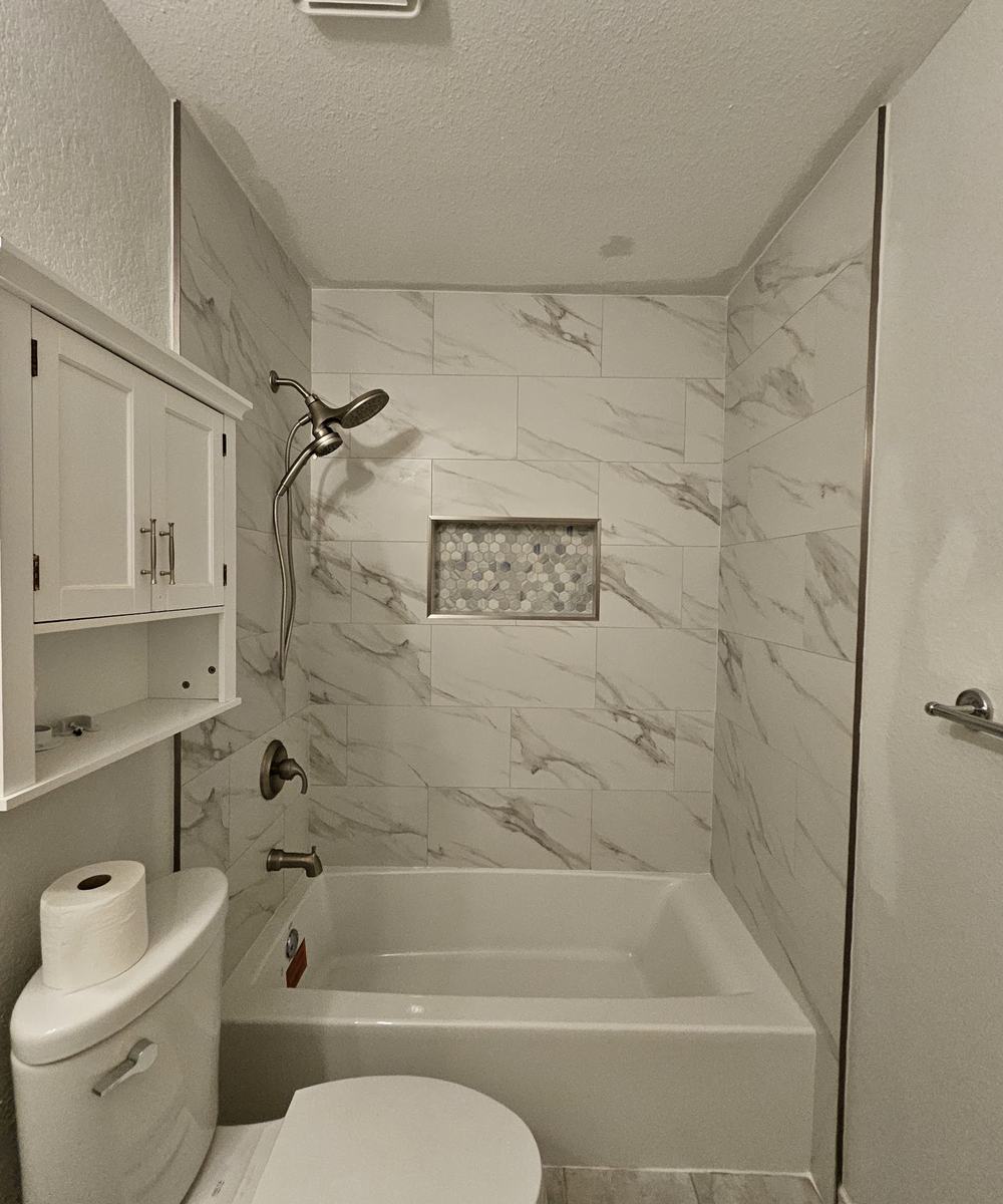 Marble-look tub surround with mosaic niche