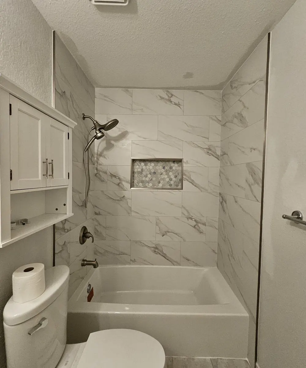 Marble-look tub surround with mosaic niche