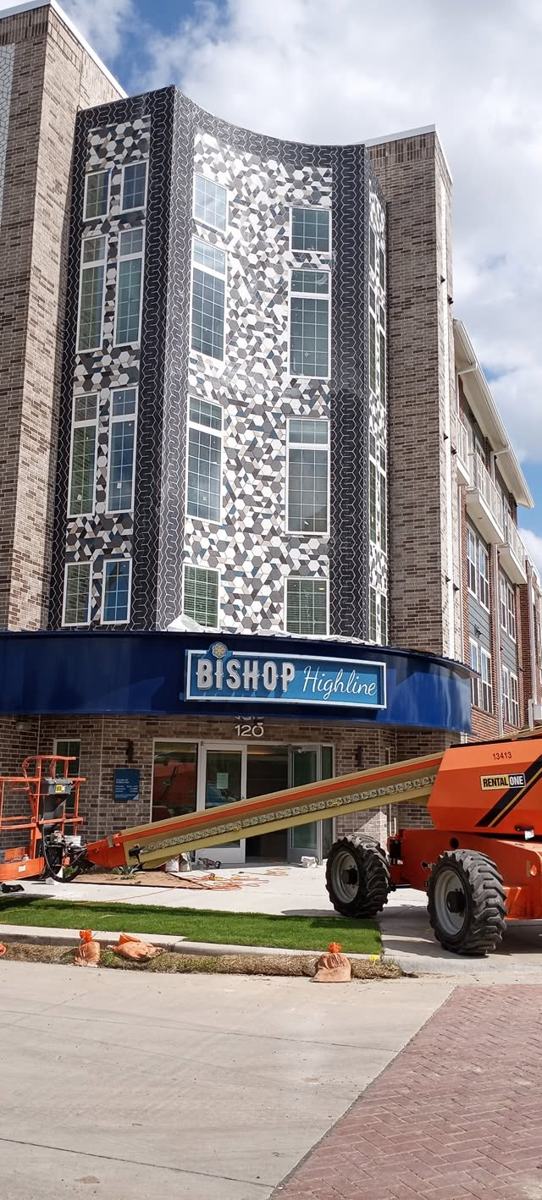 Mosaic tile facade on a multi-story building above the entrance