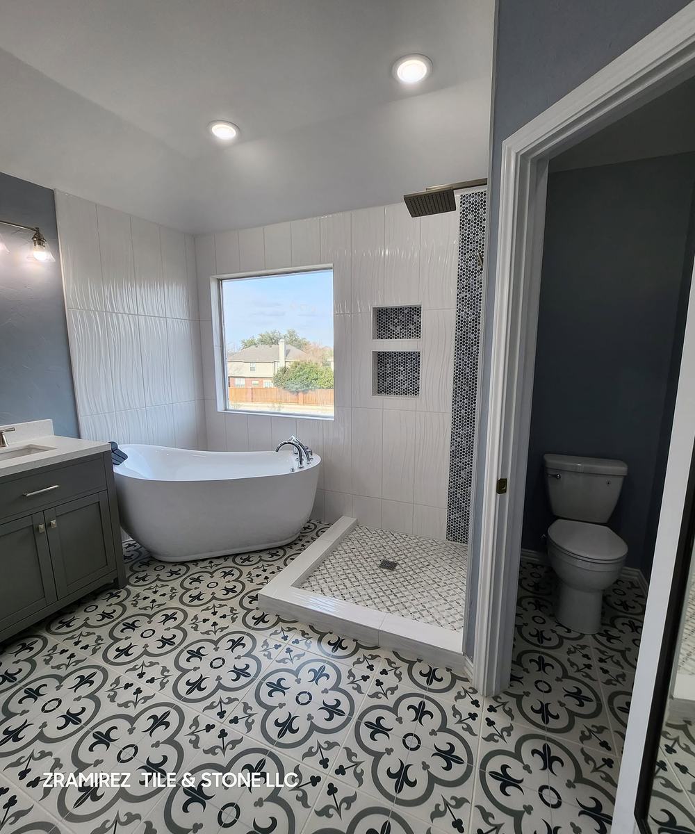 Primary bathroom with patterned porcelain floor and freestanding tub