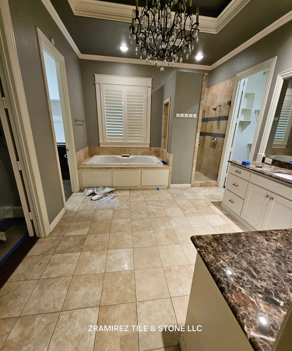 Before: Primary bathroom: dated travertine and a drop-in tub, remodeled with a marble-look walk-in shower, new floor and an infrared sauna we installed