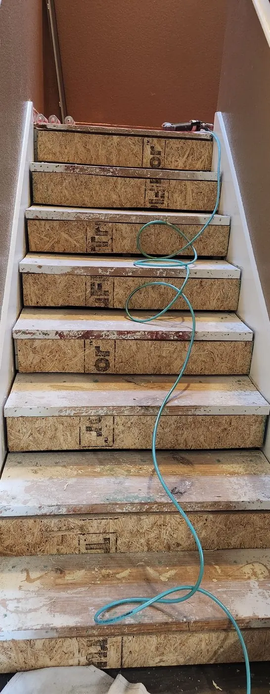 Before: Bare stair treads finished in wood-look tile