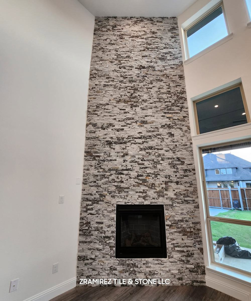 Floor-to-ceiling stacked-stone fireplace in a two-story room