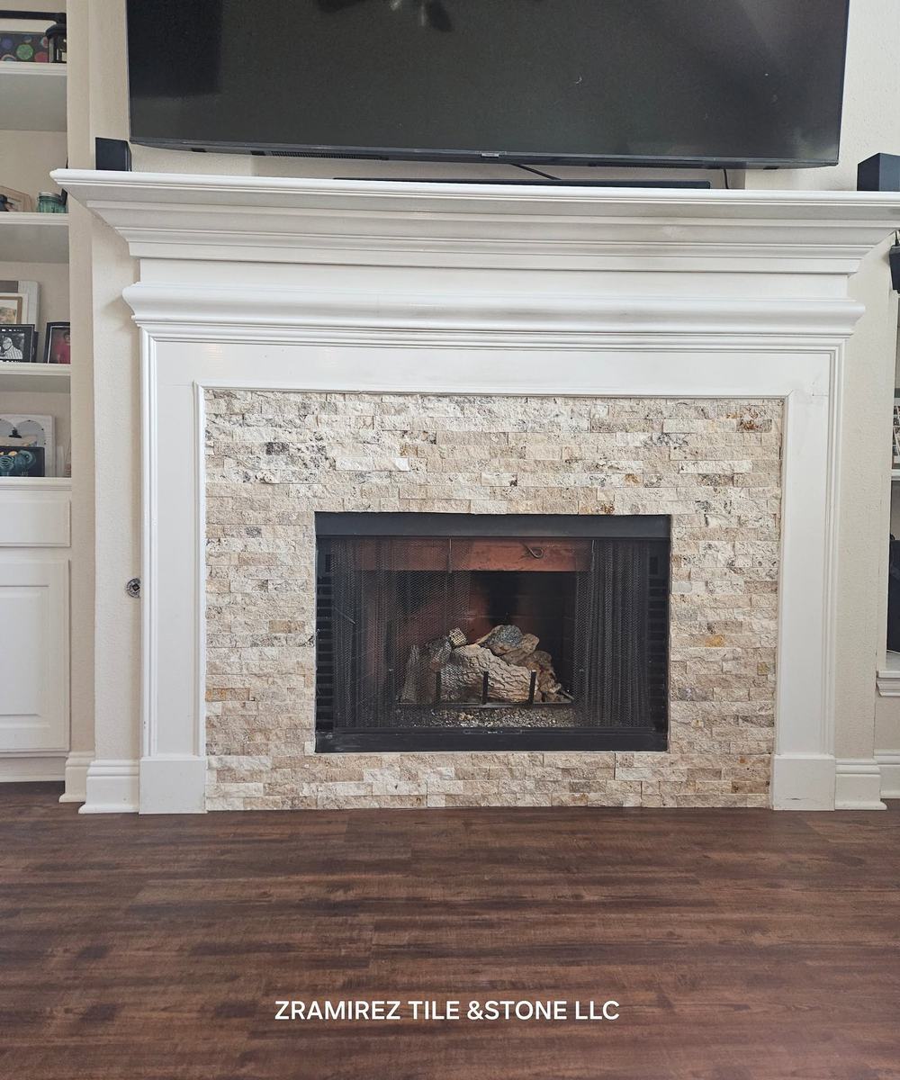 Fireplace surround in split-face stone with a white mantel