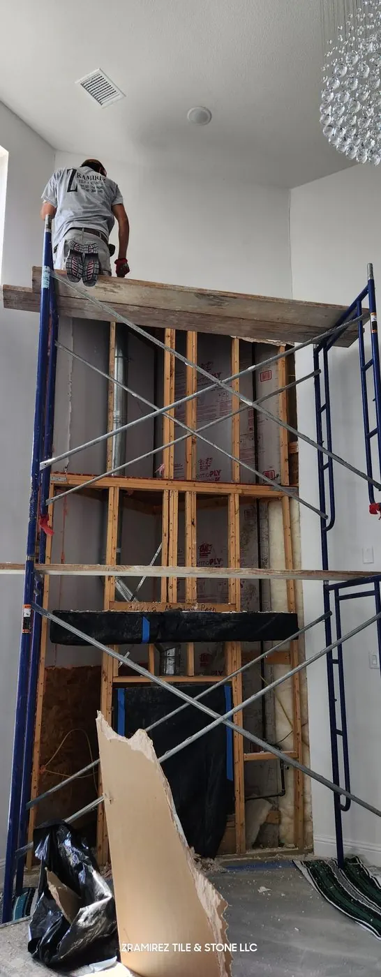 Before: Two-story fireplace wall, from framing to black marble-look large-format porcelain